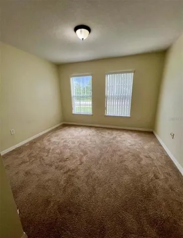 an empty room with a windows and closet