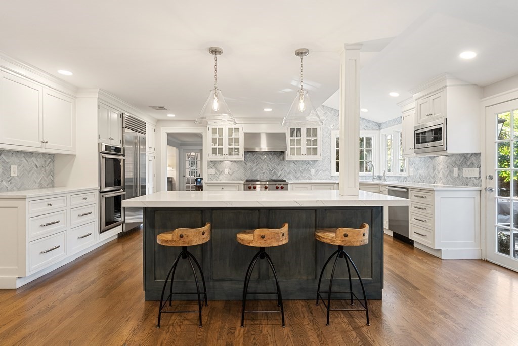 33 Damien Road Wellesley, MA 02481 - Photo 13 of 41 a kitchen with stainless steel appliances granite countertop a stove a refrigerator a kitchen island a sink white cabinets and chairs with wooden floor