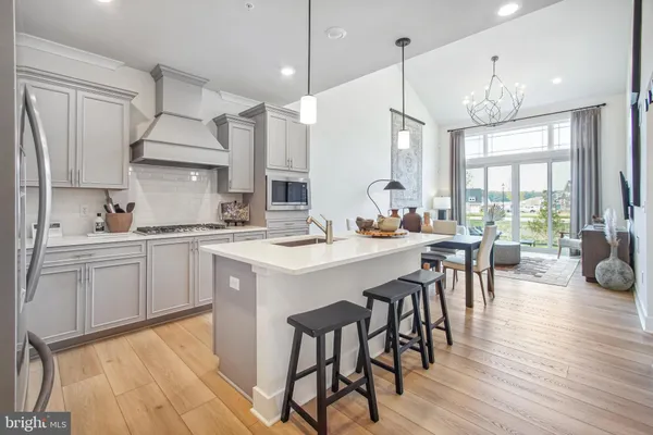 a kitchen with a dining table chairs sink and cabinets