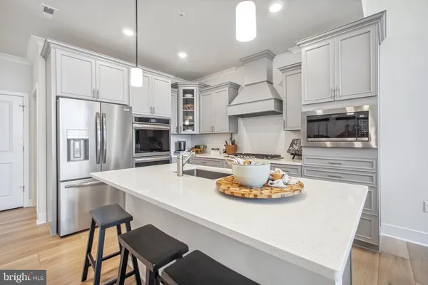 a kitchen with a sink a stove and chairs
