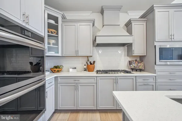 a kitchen with stainless steel appliances a stove a sink and cabinets