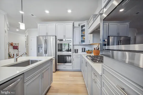 a kitchen with stainless steel appliances granite countertop a sink a stove and a refrigerator
