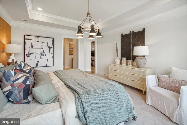 a spacious bedroom with a bed a couch and dresser