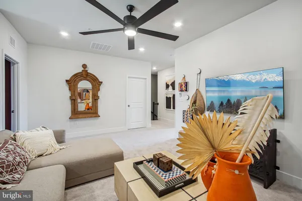 a living room with furniture ceiling fan and a rug