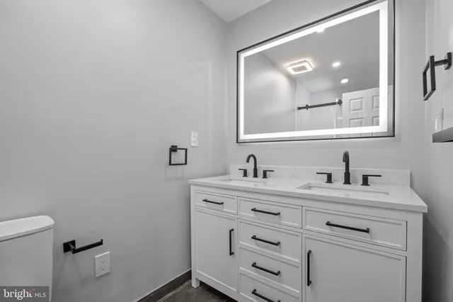 a bathroom with a sink a toilet and a mirror
