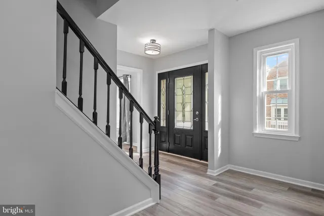 a view of an entryway with wooden floor and stairs