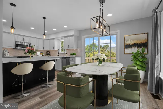 a kitchen with a dining table chairs stainless steel appliances and cabinets