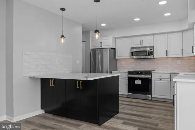 a kitchen with kitchen island granite countertop a stove and a sink