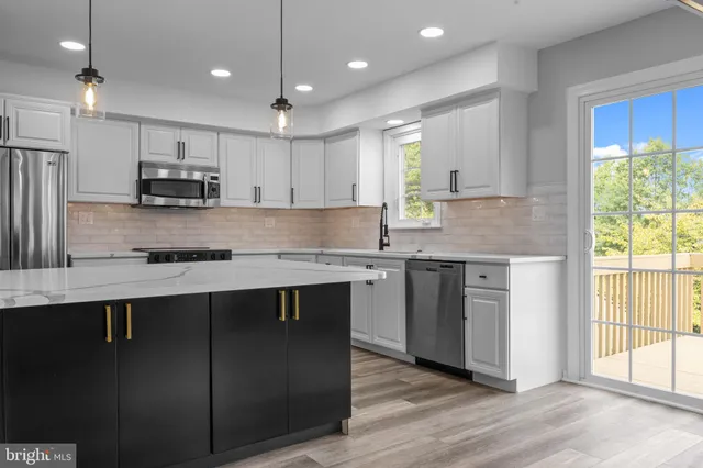 a kitchen with stainless steel appliances granite countertop a sink a stove a refrigerator and a oven