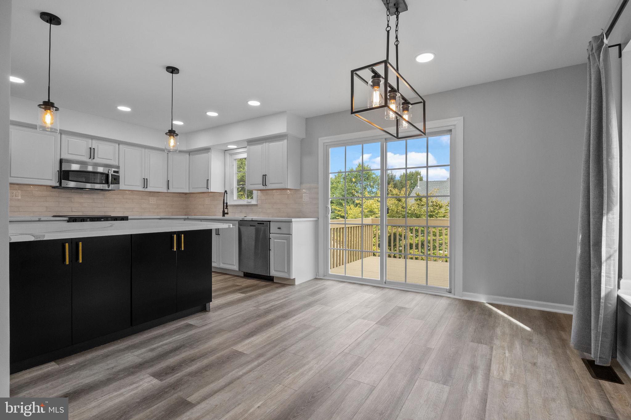 548 Susan Drive King of Prussia, PA 19406 - Photo 9 of 27 a kitchen with stainless steel appliances granite countertop a refrigerator a sink dishwasher a stove and white cabinets with wooden floor