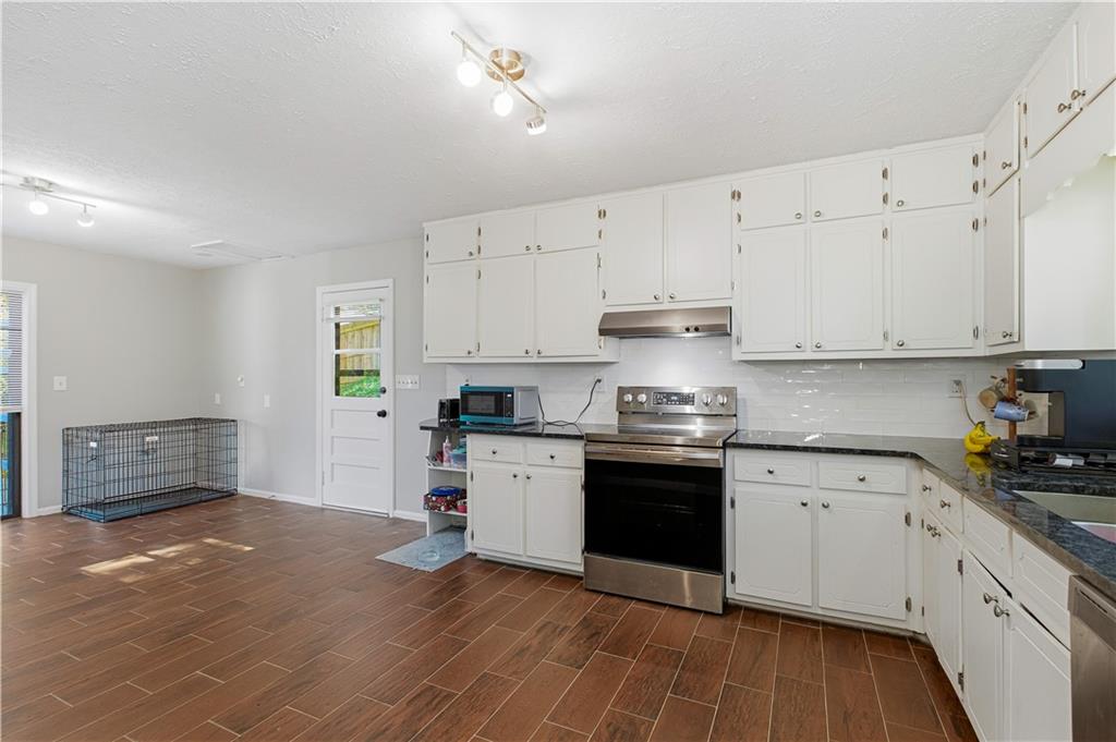 531 Crestview Terrace Gainesville, GA 30501 - Photo 11 of 54 a kitchen with granite countertop white cabinets and appliances