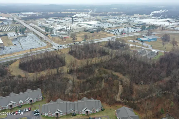 a view of a dry yard with wooden fence