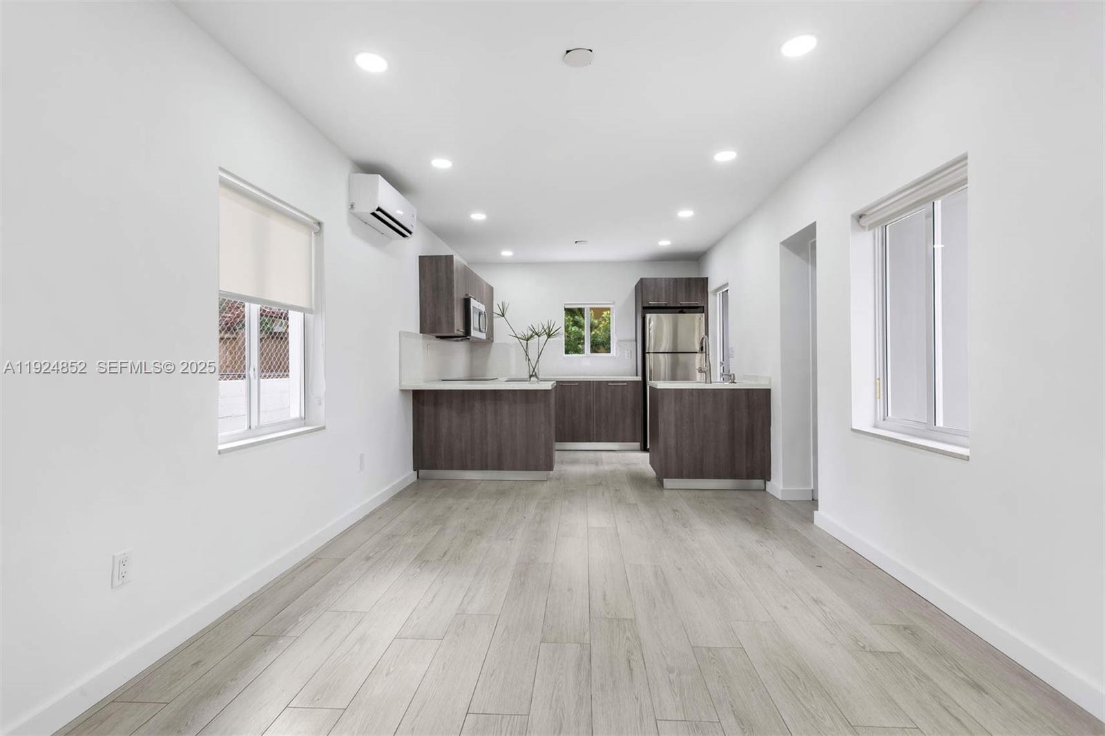 623 Northeast 61st Street, Unit 5 Miami, FL 33137 - Photo 3 of 12 a living room with stainless steel appliances kitchen island hard wood floors and fireplace