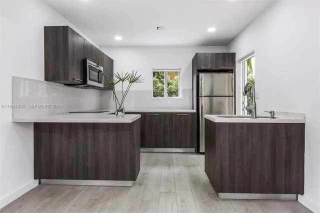 a kitchen with stainless steel appliances a refrigerator and a microwave