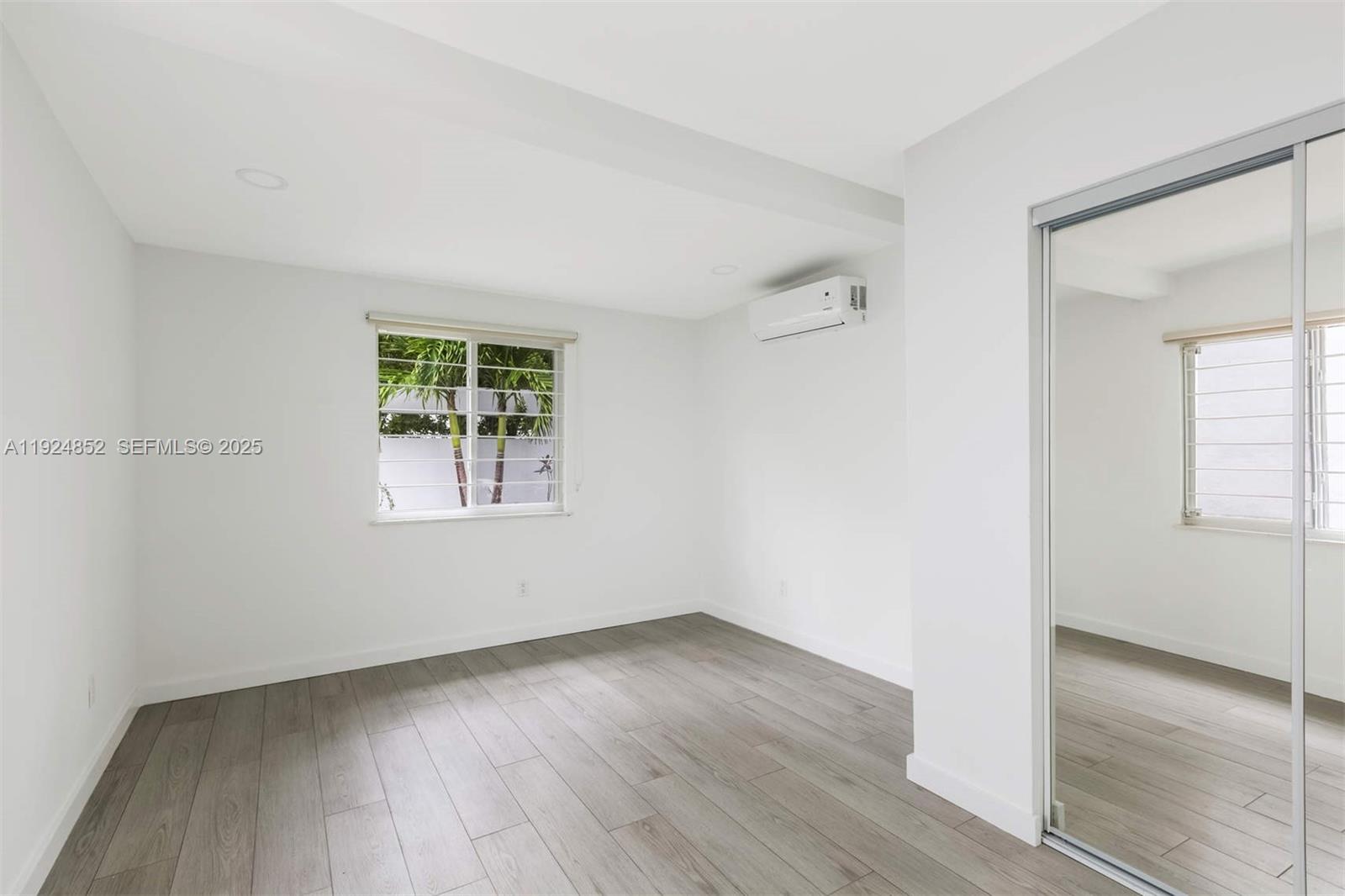 623 Northeast 61st Street, Unit 5 Miami, FL 33137 - Photo 8 of 12 an empty room with wooden floor and windows