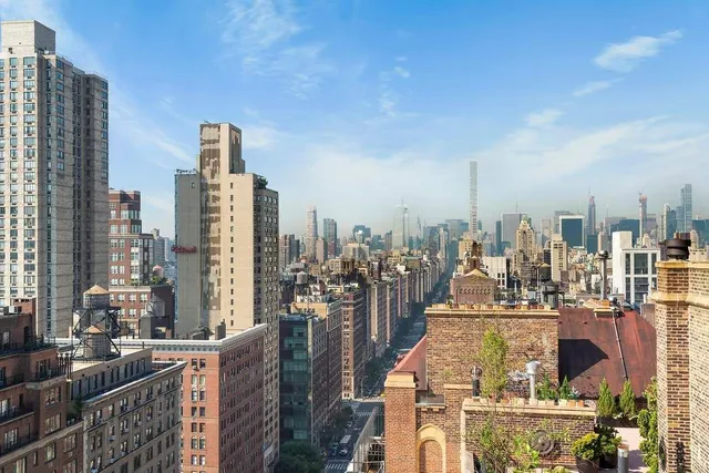 a picture of a living room with a white wall and a large mirror