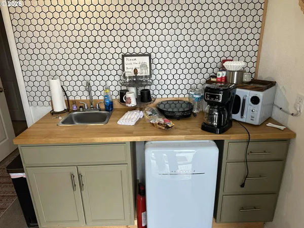 a kitchen with a sink a stove and a wooden floor