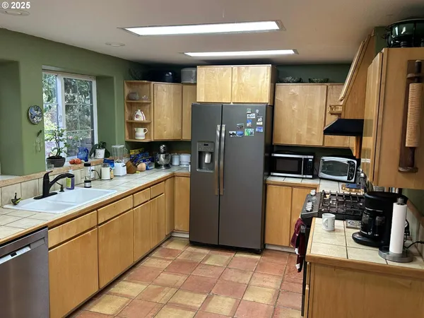 a kitchen with stainless steel appliances a refrigerator sink and microwave