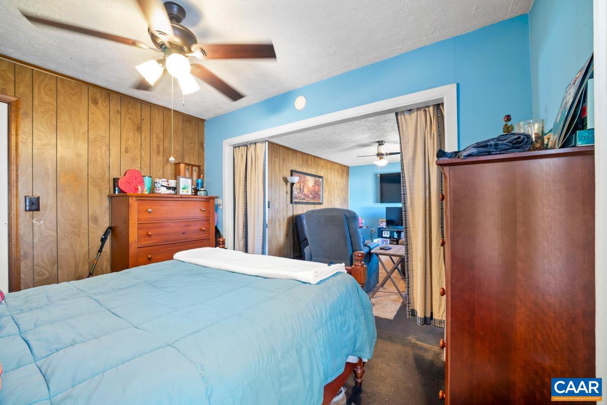 838 Matthew Mill Road Ruckersville, VA 22968 - Photo 3 of 12 a bedroom with a large bed and a chandelier