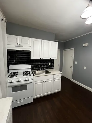 a kitchen with a stove a sink and a microwave
