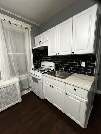 a kitchen with white cabinets and white appliances
