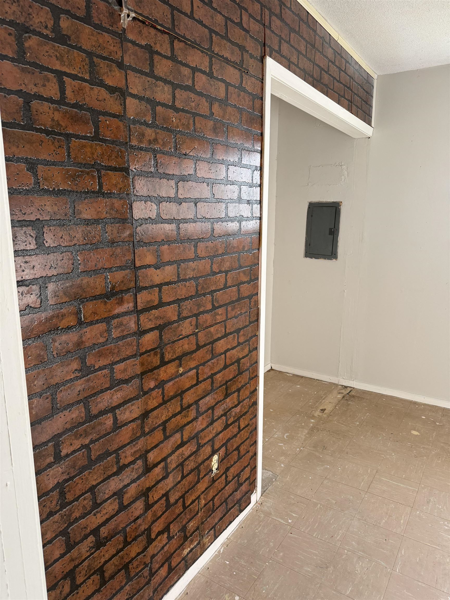 676 Nonconnah Road Memphis, TN 38109 - Photo 14 of 20 Detailed view of tile patterned floors, brick wall, and electric panel