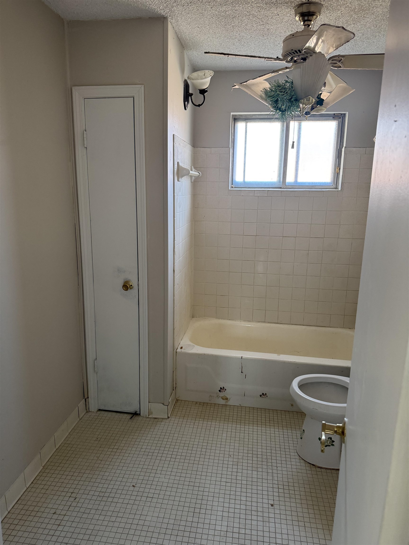 676 Nonconnah Road Memphis, TN 38109 - Photo 15 of 20 Full bath with a ceiling fan, a textured ceiling, shower / bath combination, and light tile patterned floors