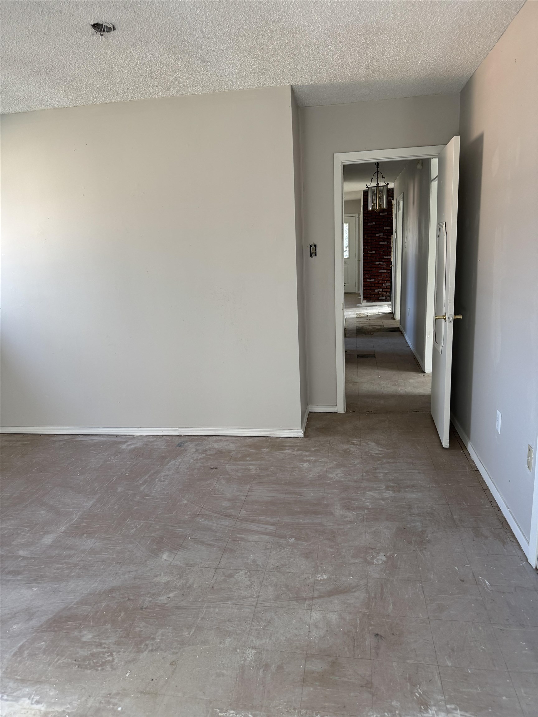 676 Nonconnah Road Memphis, TN 38109 - Photo 18 of 20 Unfurnished room featuring a textured ceiling, suspended lighting, and tile patterned floors