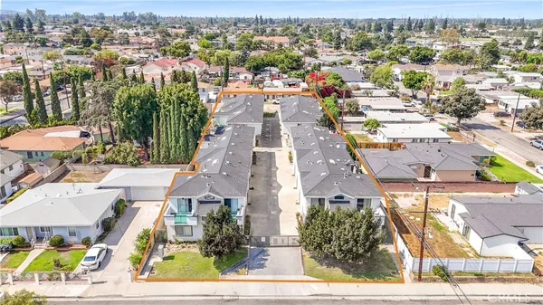 an aerial view of residential houses with outdoor space and parking
