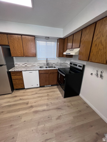 556 North Fairfield Road, Unit D4 Layton, UT 84041 - Photo 21 of 23 Kitchen featuring stainless steel appliances, brown cabinetry, light wood finished floors, and light countertops