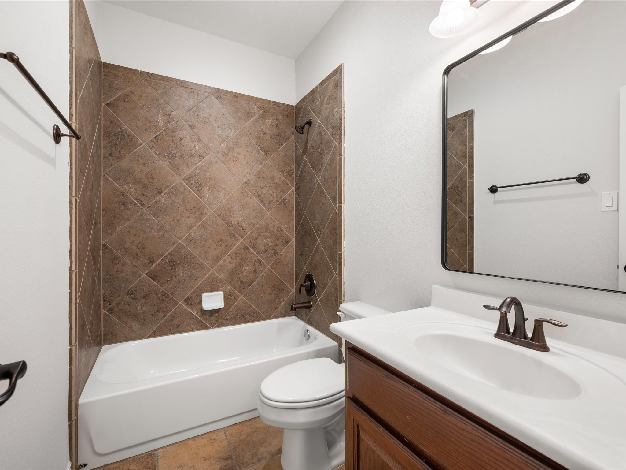 323 Arbor Ridge Lane Conroe, TX 77384 - Photo 26 of 40 Clean, classic, and ready to go. Tub-shower combo, great vanity space, and that tile work holds up. Kids' bath, guest bath, you're covered either way.