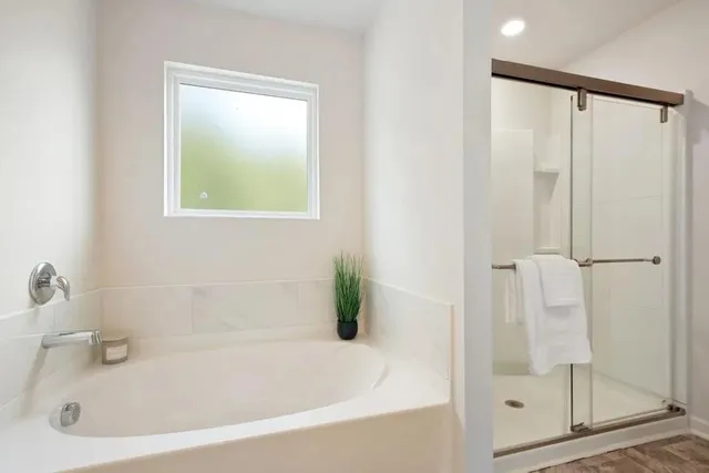 a white bath tub sitting next to a shower