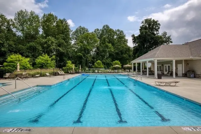 a view of house with yard and swimming pool