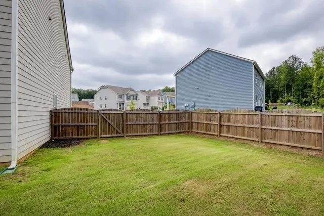 a view of a backyard with wooden fence