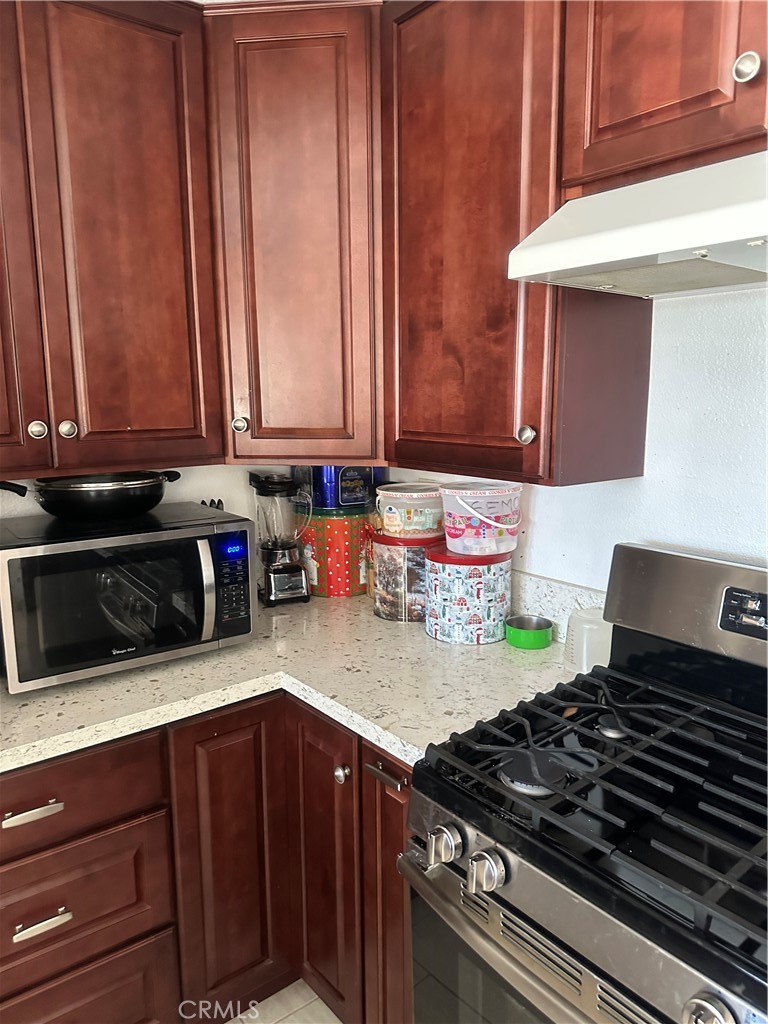 1029-1029 West Madrona Street Rialto, CA 92376 - Photo 14 of 19 a kitchen with wooden cabinets and a stove top oven
