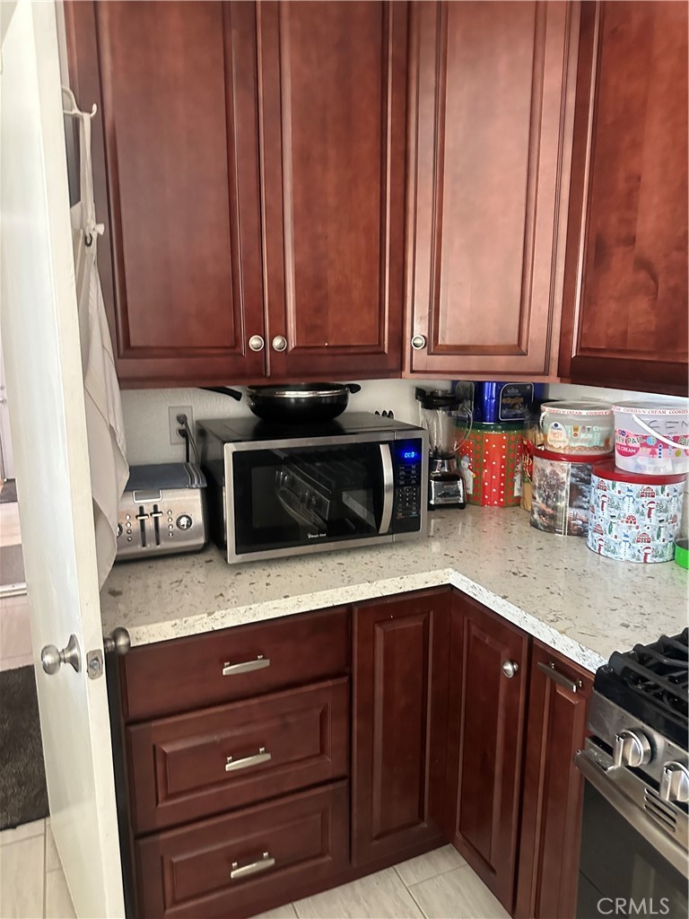 1029-1029 West Madrona Street Rialto, CA 92376 - Photo 15 of 19 a kitchen with granite countertop cabinets and black appliances