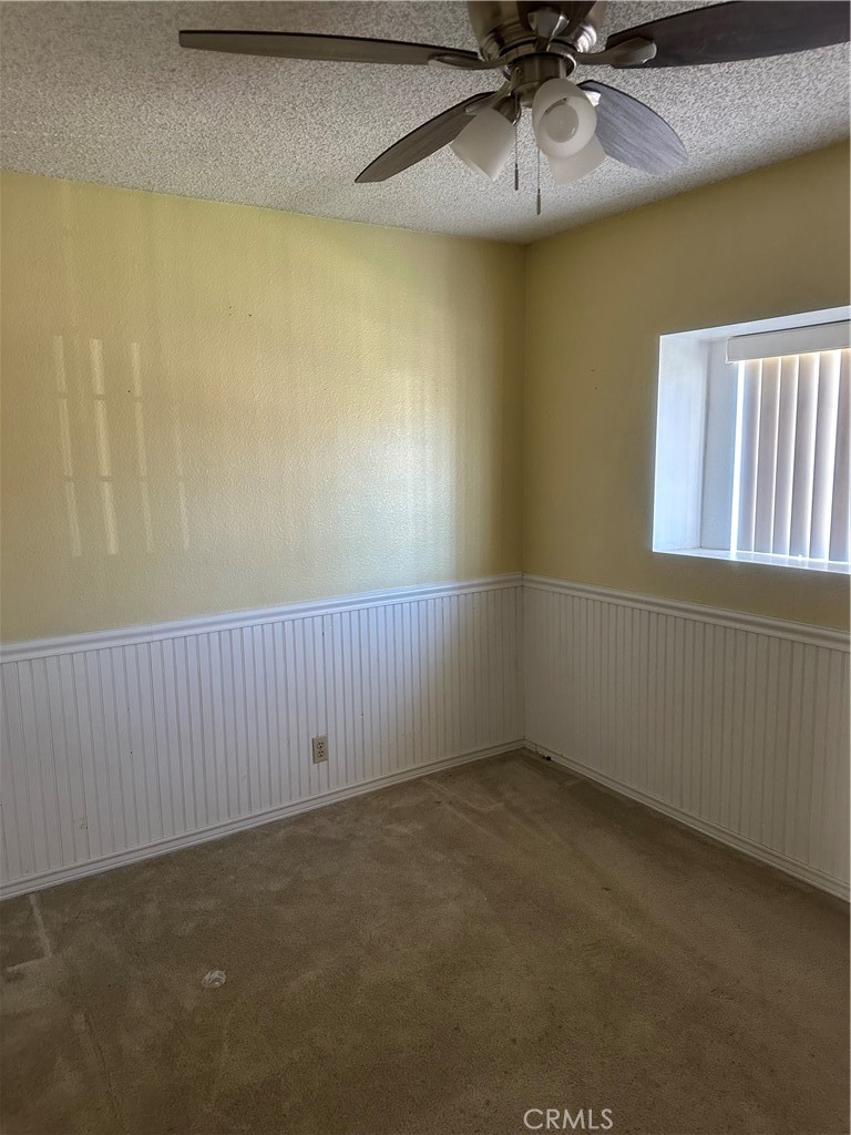 1029-1029 West Madrona Street Rialto, CA 92376 - Photo 6 of 19 an empty room with a ceiling fan and window