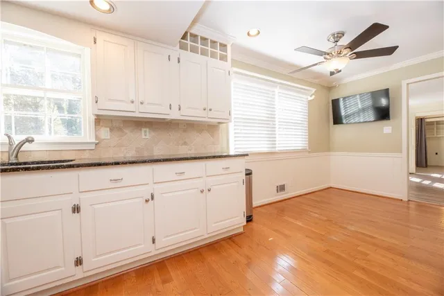 a view of a kitchen with a sink and dishwasher a refrigerator with wooden floor
