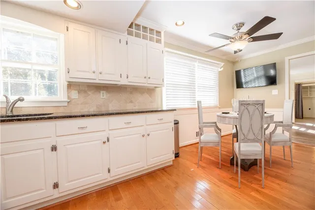 a view of a room with wooden floor electronic appliances and windows