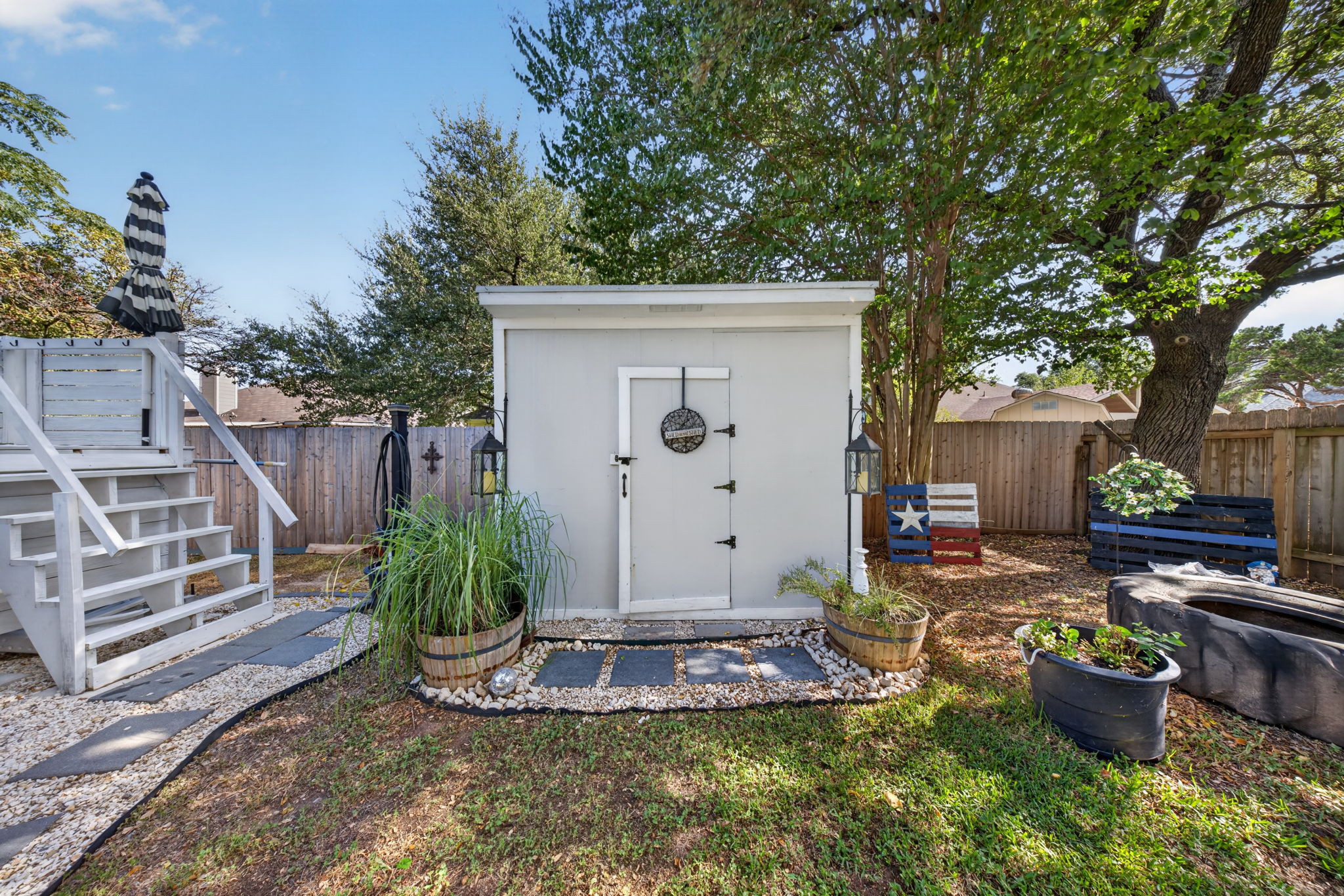 806 Mountain Ridge Drive Leander, TX 78641 - Photo 26 of 40 A detached storage shed stands in the fenced backyard adjacent to a raised deck.