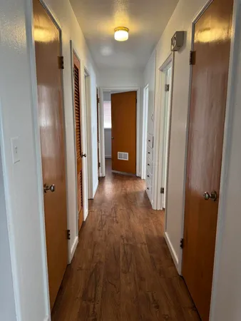 a view of a hallway with wooden floor