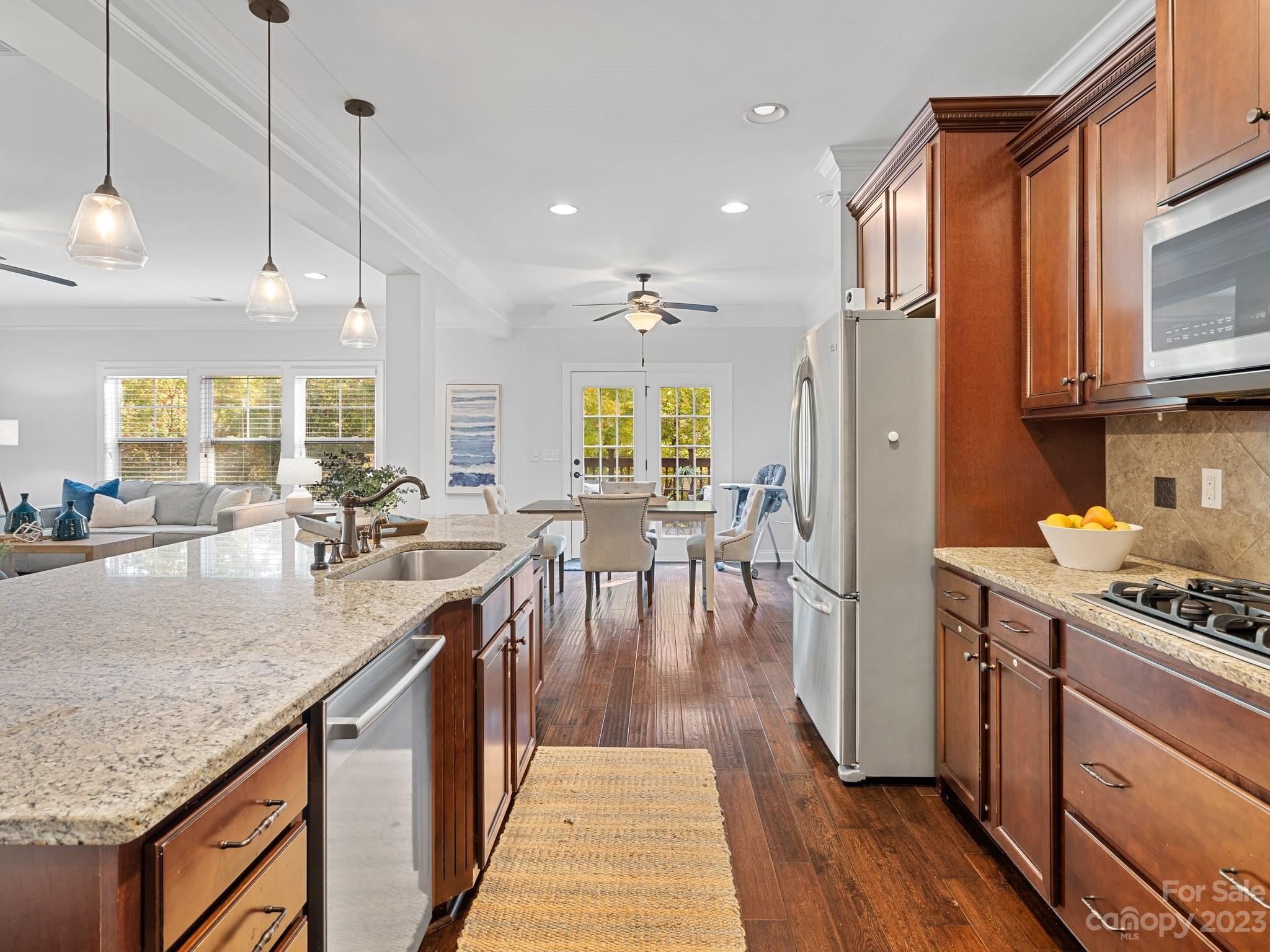1021 Ridgehaven Road Waxhaw, NC 28173 - Photo 12 of 36 a kitchen with stainless steel appliances granite countertop a stove a sink dishwasher a refrigerator a dining table and chairs with wooden floor