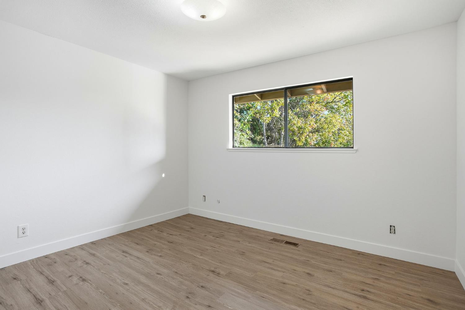 6923 Pera Drive Rancho Murieta, CA 95683 - Photo 25 of 35 an empty room with wooden floor and a window