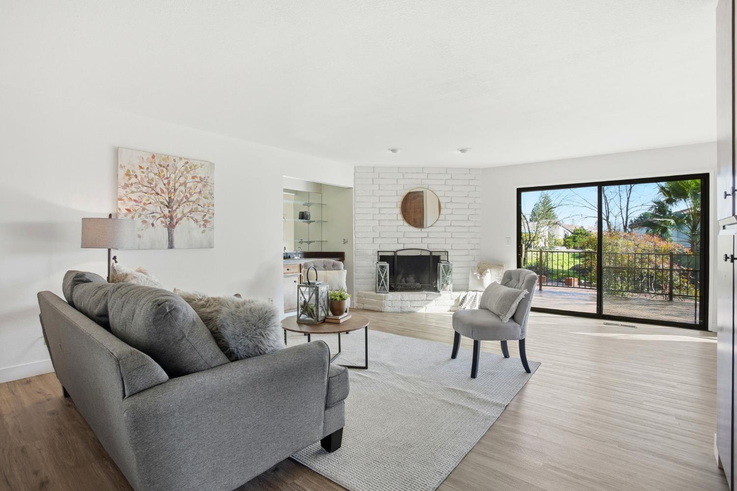 6923 Pera Drive Rancho Murieta, CA 95683 - Photo 9 of 35 a living room with furniture a fireplace and a floor to ceiling window