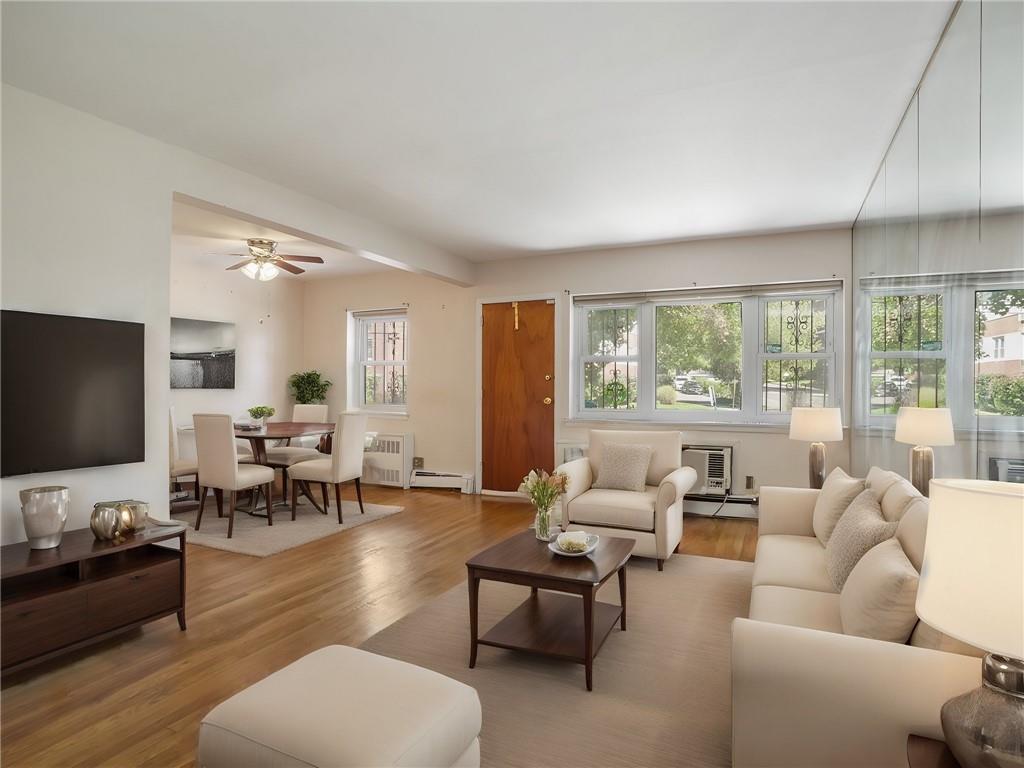 665 Pelham Road, Unit A11 New Rochelle, NY 10805 - Photo 1 of 1 Virtually Staged -Living room with a baseboard radiator, an AC wall unit, light hardwood / wood-style floors, and ceiling fan