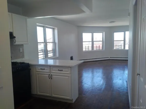 a view of a kitchen with wooden floor and a window