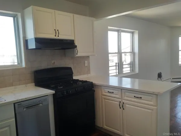 a kitchen with granite countertop white cabinets and a stove