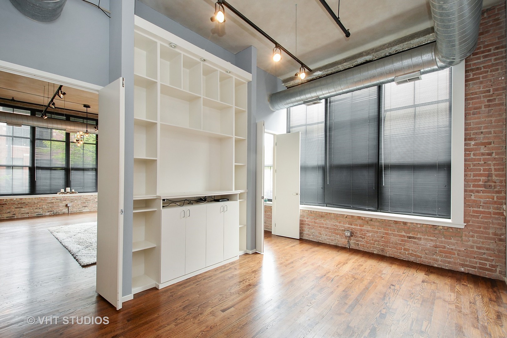 817 West Washington Boulevard, Unit 103 Chicago, IL 60607 - Photo 7 of 10 a view of an empty room with a window and wooden floor