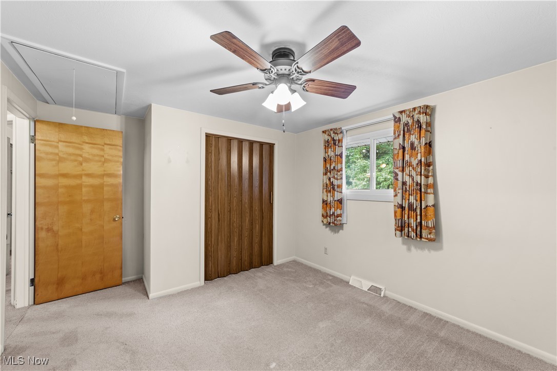 648 Rehwinkle Road Northfield, OH 44067 - Photo 17 of 38 Unfurnished bedroom featuring attic access, carpet flooring, a ceiling fan, and a closet