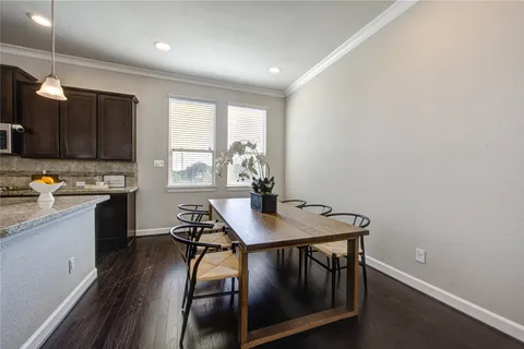 a kitchen with a table chairs a sink dishwasher window and cabinets